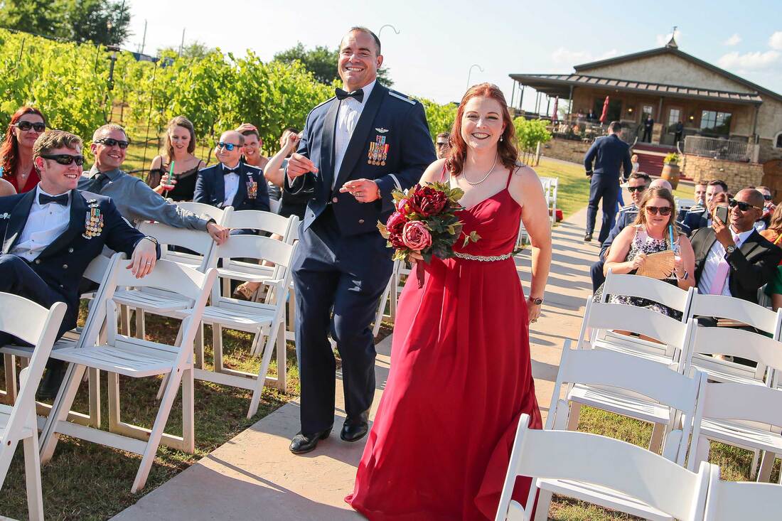 candid photo best man and maid of honor dancing down the aisle in OKC