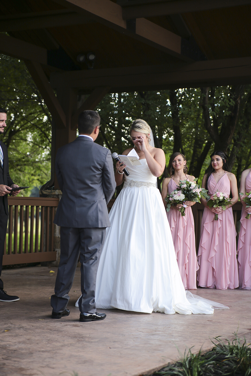 Bride crying as she reads her handwritten custom wedding vows at the springs in Edmond, Oklahoma 