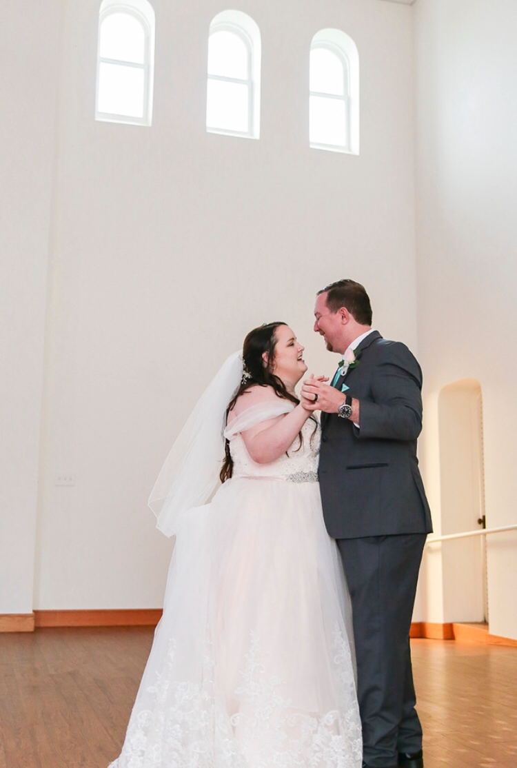 The bride and groom during their first dance on the stage at Darlington Chapel in El Reno, Oklahoma 
